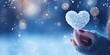 Winter snow christmas Valentine background greeting card - Closeup of woman with gloves holding a rod heart in her hands, defocused blurred bacground with snowflakes