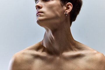 Close up cropped portrait of young male body. Naked shoulders, neck, collarbones, bust of man. Skincare cosmetic treatment affect.