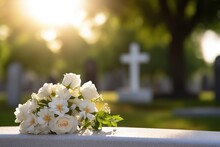 White Flowers In Front Of A Gravestone At A Cemetery With Sunset.Funeral Concept