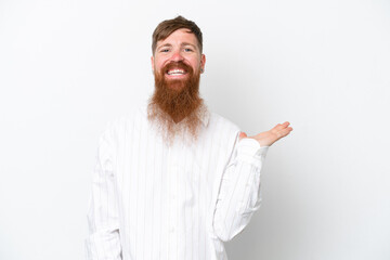 Wall Mural - Redhead man with long beard isolated on white background holding copyspace imaginary on the palm to insert an ad