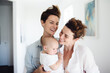 © Jasmina - Portrait of happy female Gay couple with baby at home. Concept of lgbt people, lesbian marriage and adoption, homosexual family
