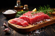 Fresh piece of raw tuna is displayed on cutting board, accompanied by variety of spices and sprinkle of salt. Preparation of sushi or as representation of healthy dish seafood.
