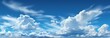 A tranquil panorama of the blue sky painted with wispy white clouds