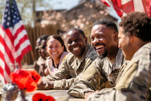 Group Of Happy African American Military Men, Women, War Veterans On A Sunny Day In A Street Cafe Sharing Memories And Talking About Service Together. Flag On Background. Remembrance, Independence Day