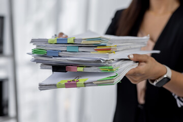 Wall Mural - Businesswoman hands working in Stacks of paper files for searching and checking unfinished document achieves on folders papers at busy work desk office
