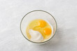 Glass bowl with semolina, sugar and eggs on a gray background, top view. Cooking coconut semolina pie mannik with apples, do it yourself, step by step