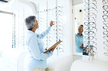 Canvas Print - Glasses, eye care or senior woman with retail in store for checklist stock, inventory or eyewear choice. Vision, ophthalmology or optician in frame clinic with clipboard for product in optometry shop