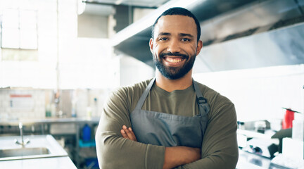 Wall Mural - Happy man, face and small business owner in kitchen at restaurant for hospitality service, cooking or food. Portrait of male person, employee or waiter smile in confidence for professional career