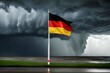 Deutschlandflagge auf freiem Feld mit Gewitter und Blitzen im Hintergrund