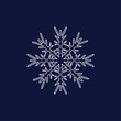 Snowflake white openwork symmetrical on a blue background, looks like a crystal spider web