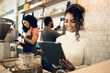 © N F/peopleimages.com - Happy woman, tablet and small business at cafe in management, network or ownership at coffee shop. Female person, entrepreneur or restaurant owner smile with technology, team and barista in store