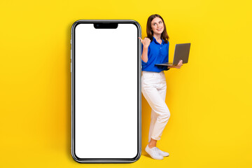 Sticker - Full length photo of sweet beautiful lady wear blue shirt pointing thumb back modern device empty space isolated yellow color background