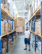 man in warehouse holding boxes in white t-shirt