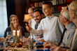 © Drazen - Happy Jewish boy lighting menorah during family meal on Hanukkah.