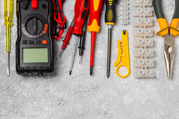 Wall Mural - Electrician tools on background.Multimeter,construction tape,electrical tape, screwdrivers,pliers,an automatic insulation stripper, socket and LED lamp.Flatley.electrician concept.