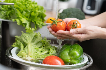 Wall Mural - people washing raw vegetables at sink in the kitchen prepare ingredient for cooking