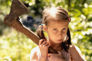 Humorous portrait of young female lumberjack with a large aх before felling of trees