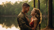 In a serene lakeside setting, a Marine Corps corporal beams with happiness as he reunites with his spouse, their smiles a testament to their enduring love. 