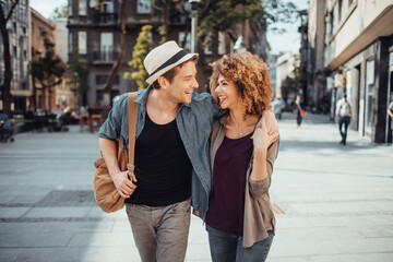 Poster - Young mixed couple embracing each other while having a stroll in the city