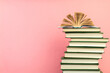 Open book, hardback books on wooden table, on a pink background. Back to school. Copy space for text. Education background.