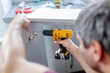 © zphoto83 - Carpenter fixing kitchen cabinet door by using electrical screwdriver