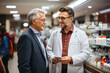 © Degimages - Pharmacist and customer in pharmacy next to shelves with medicines.