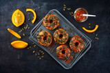 Traditionelle amerikanische Herbst Donuts graniert mit Kürbiskernen und Kürbisglasur und serviert als Draufsicht auf einem Backblech mit Gitter