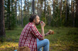 © DimaBerlin - Man hiker drinking tea from mug during hiking in forest. Male during small halt eating sandwich and drinking coffee in autumn woodland, resting stopped for break after walk in woods.