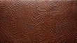 Closeup of embossed saddle leather This texture features a deep texture with raised shapes and patterns that have been stamped onto the leather. The embossing adds a touch of elegance and