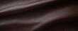 Texture of fullgrain buffalo leather, featuring a smooth and glossy surface in a rich, dark brown shade. The luxurious appearance and natural markings make it a popular choice for luxury