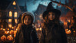 Children in costumes of witch in front of a dark house in holiday Halloween.