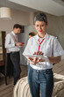 © Miljan Živković - one woman female entrepreneur team leader stand in front of her colleagues in hotel room prepare for business conference meeting real people entrepreneurs copy space