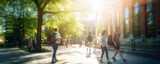 Fototapeta Uliczki - Crowd of students walking through a college campus on a sunny day, motion blur