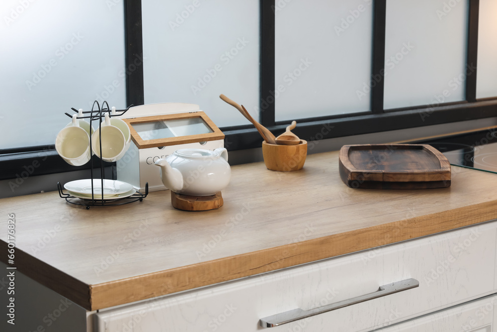 Kitchen counter with cutting board, teapot and cup rack