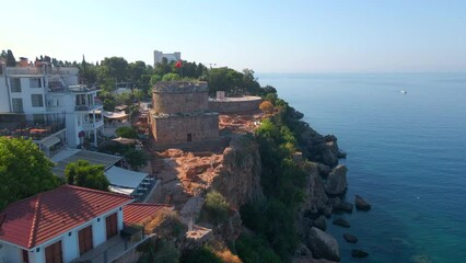 Wall Mural - Enjoy a breathtaking view of Hidirlik Tower, an iconic symbol of Antalya's historical center, in this mesmerizing aerial stock video. The tower, with its ancient charm and stunning location