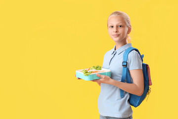 Poster - Happy girl with backpack and lunchbox on yellow background