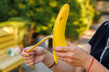 Woman's hand holding bananas, snack and fast food concept. Selective focus on hands with blurred background