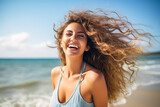 Fototapeta  - Portrait of a very happy young woman loving the life shes living  having fun on the beach with the surf in the background having fun relaxing no cares or worries holiday vacation in the sun