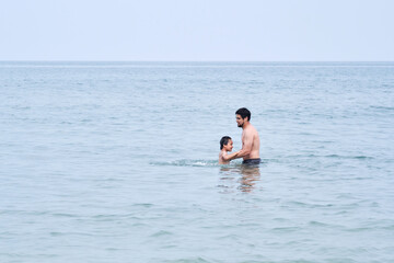 Wall Mural - Dad plays with his sons in the sea.