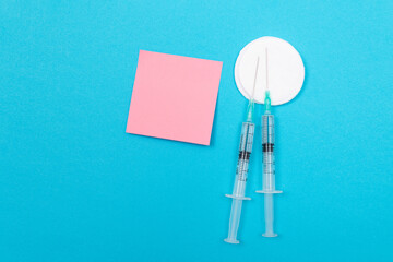 vaccination, immunology or revaccination concept - two medical disposable syringe lying on blue tabl