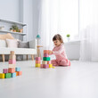 © Natali - On a white background, a girl builds a tower from cubes, a girl plays with cubes, a beautiful little girl