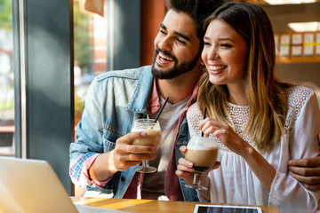 Wall Mural - Romantic couple in cafe is drinking coffee and enjoying being together