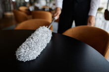 Close Up Of Water Wiping Dining Tables With Feather Duster In Luxury Dining Room Setting, Copy Space