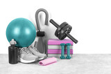 Fototapeta Sypialnia - Different sports equipment on a gray background, front view, copy space. Home workout. Fitness and activity. 