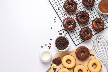 Wall Mural - Chocolate donuts, bowls and whisk on white background, space for text