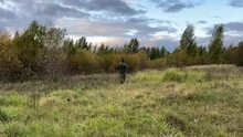 Hunters On Hunt. A Hunter Walks Through Forest Among Trees In Search Of Wild Birds Or Wild Animals. Hunters With Gun And Rifle On Hunting In Fall Season. Hunter During Hunting On Elk In Forest. 