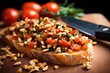a knife spreading tomato topping on a bruschetta, pine nuts loosely scattered