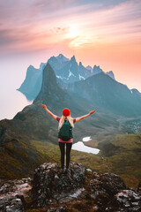 Wall Mural - Traveler woman with backpack hiking in Norway girl raised arms alone on mountain top outdoor travel summer vacations active healthy lifestyle success motivation concept explore Senja island