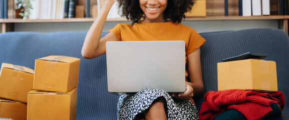 Wall Mural - Young woman holding a smartphone, tablet showing payment success with yellow parcel box as online shopping concept