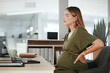 © Malambo C/peopleimages.com - Pregnant, woman and back pain in office with tired, burnout and relax with eyes closed at desk or table. Person, pregnancy and hand on stomach for risk, anxiety or stress at professional company